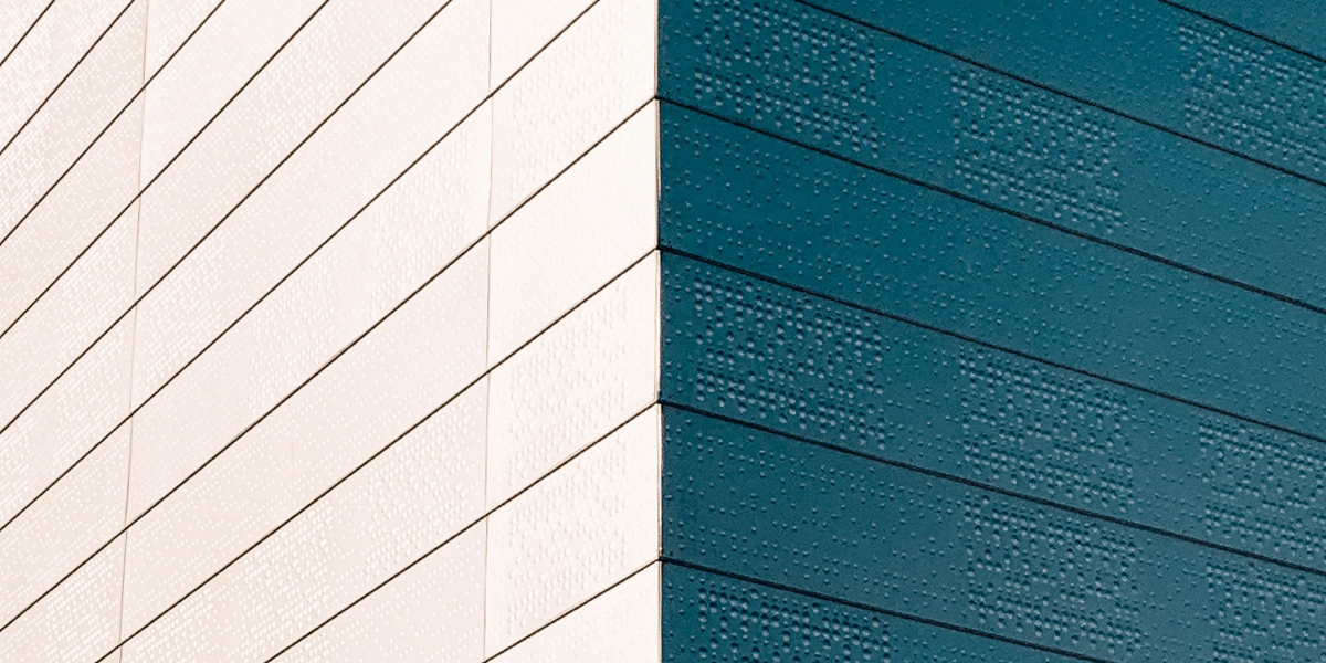 The corner of a white and blue building in focus, with white on the left and blue on the right representing the divide between developers when it comes to accessibility practices.