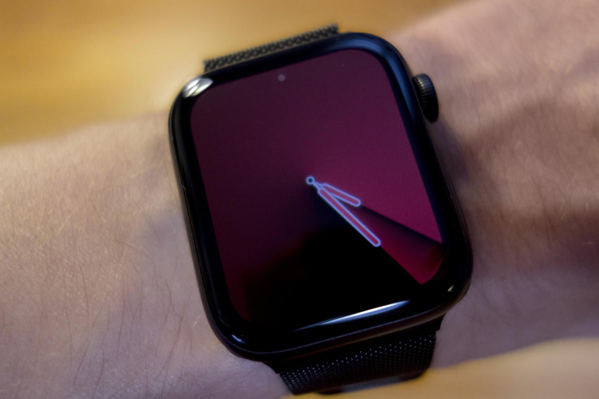 Black Apple Watch on a person's wrist showing a deep purple conic gradient face.